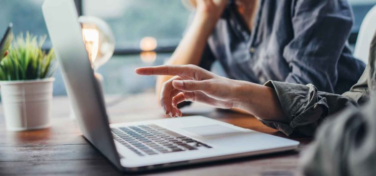 Zwei Mitarbeiter - Ein Fingerzeig auf den Bildschirm eines Laptops.